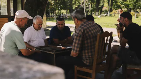 Ältere Männer spielen gemeinsam Backgammon im Park